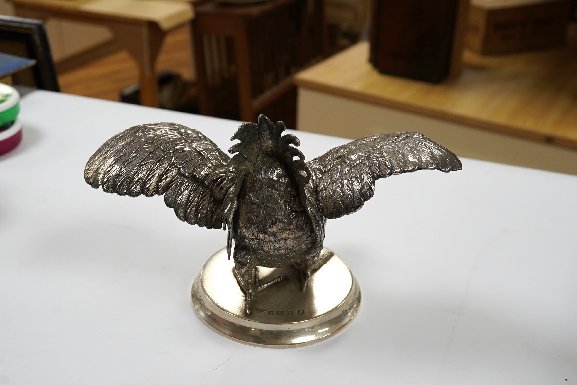 An Elizabeth II silver presentation cockerel, on a circular base with engraved inscription, by Garrard & Co Ltd, London, 1953, overall height 14cm, weighted. Condition - fair to good